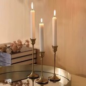 Набір елегантних металевих свічників золотистого кольору, підсвічники